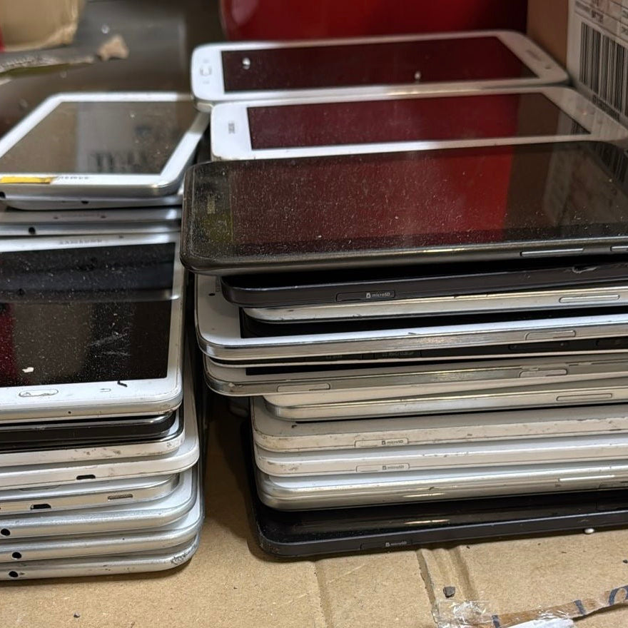 Stacks of old tablets on a table with a red wall in the background